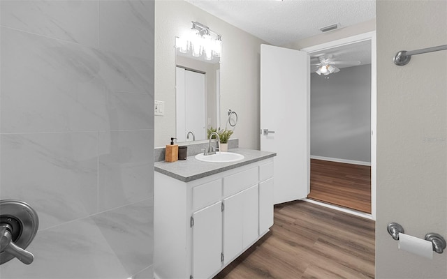 2614 W Idlewild Ave, Tampa, FL 33614 - bathroom featuring ceiling fan, vanity, a textured ceiling, and wood finished floors