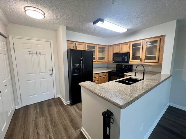 2400 Feather Sound Dr Unit 935, Clearwater, FL 33762 - kitchen featuring black appliances, dark wood-style floors, a peninsula, glass insert cabinets, and a textured ceiling