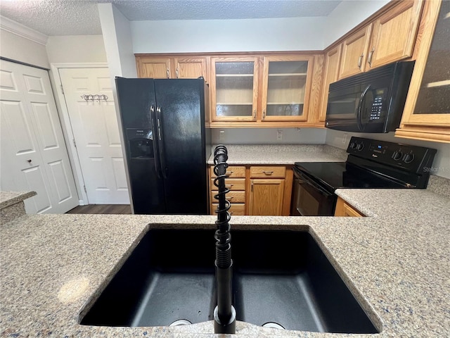 2400 Feather Sound Dr Unit 935, Clearwater, FL 33762 - kitchen with black appliances, light countertops, a textured ceiling, and glass insert cabinets