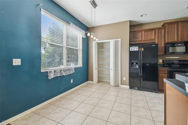 10343 Avelar Ridge Dr, Riverview, FL 33578 - kitchen with black appliances, dark countertops, light tile patterned floors, brown cabinetry, and pendant lighting