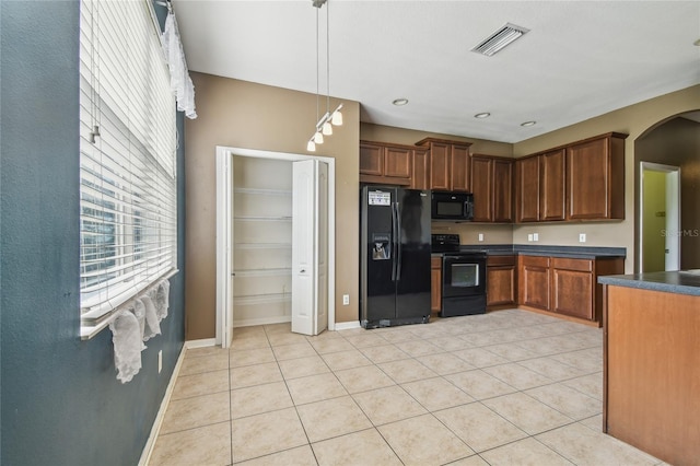10343 Avelar Ridge Dr, Riverview, FL 33578 - kitchen with black appliances, dark countertops, arched walkways, and light tile patterned floors
