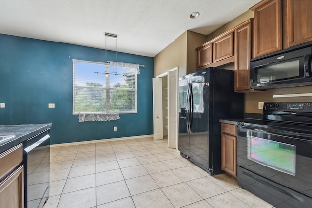 10343 Avelar Ridge Dr, Riverview, FL 33578 - kitchen featuring black appliances, dark countertops, light tile patterned floors, brown cabinets, and hanging light fixtures