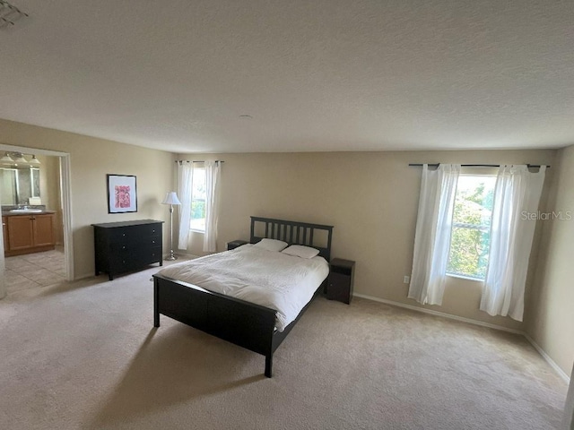 7618 Tangle Rush Dr, Gibsonton, FL 33534 - bedroom featuring multiple windows, light colored carpet, ensuite bathroom, and a textured ceiling