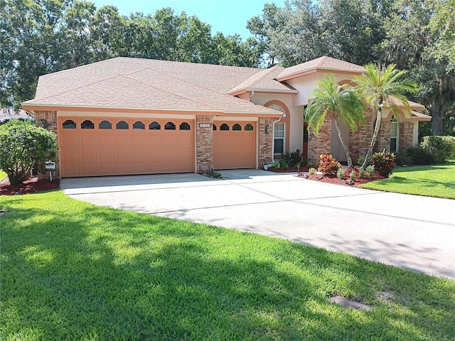 3740 Emerald Ln, Mulberry, FL 33860 - mediterranean / spanish house featuring a garage, a front yard, driveway, and stucco siding