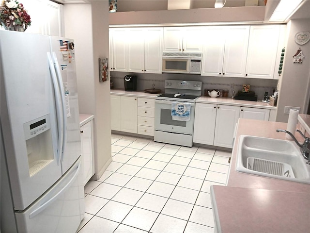 3740 Emerald Ln, Mulberry, FL 33860 - kitchen featuring white appliances, light tile patterned floors, white cabinetry, and light countertops