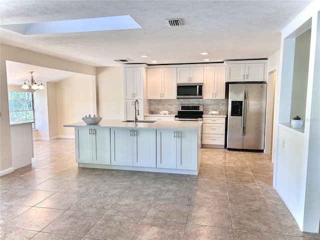 17017 Paula Ln, Lutz, FL 33558 - kitchen featuring appliances with stainless steel finishes, backsplash, light countertops, a chandelier, and a textured ceiling