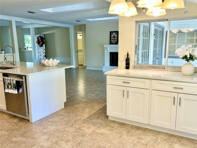 17017 Paula Ln, Lutz, FL 33558 - kitchen featuring stainless steel dishwasher, a skylight, open floor plan, and white cabinetry