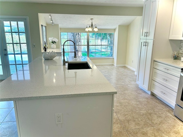 17017 Paula Ln, Lutz, FL 33558 - kitchen with plenty of natural light, a chandelier, white cabinetry, and an island with sink