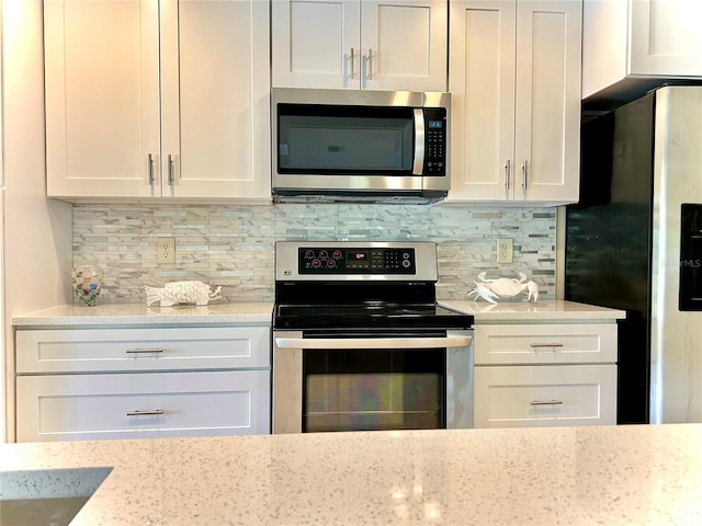 17017 Paula Ln, Lutz, FL 33558 - kitchen with stainless steel appliances, white cabinetry, backsplash, and light stone counters