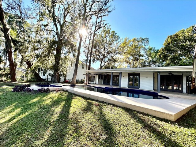 17017 Paula Ln, Lutz, FL 33558 - rear view of property featuring a ceiling fan, a lawn, french doors, an outdoor pool, and a patio