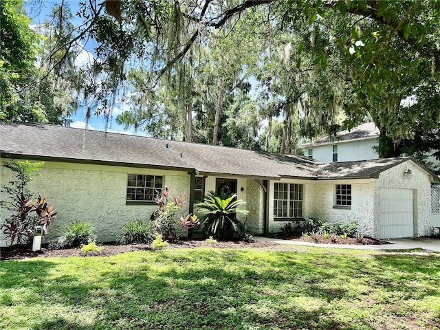 17017 Paula Ln, Lutz, FL 33558 - view of front of home featuring a garage, a front lawn, and stucco siding