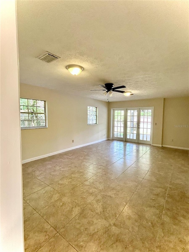 17017 Paula Ln, Lutz, FL 33558 - unfurnished room with a textured ceiling, light tile patterned floors, ceiling fan, and french doors