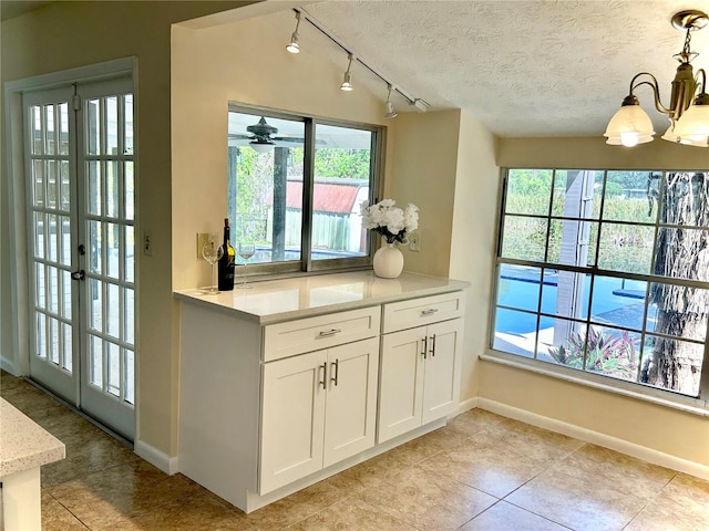 17017 Paula Ln, Lutz, FL 33558 - kitchen featuring rail lighting, healthy amount of natural light, a chandelier, and a textured ceiling