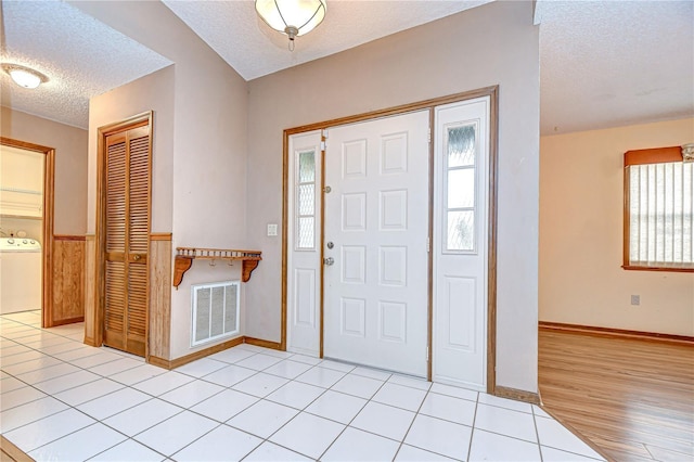 11070 Tilburg St, Spring Hill, FL 34608 - foyer entrance with washer / dryer, a textured ceiling, and light wood-style flooring