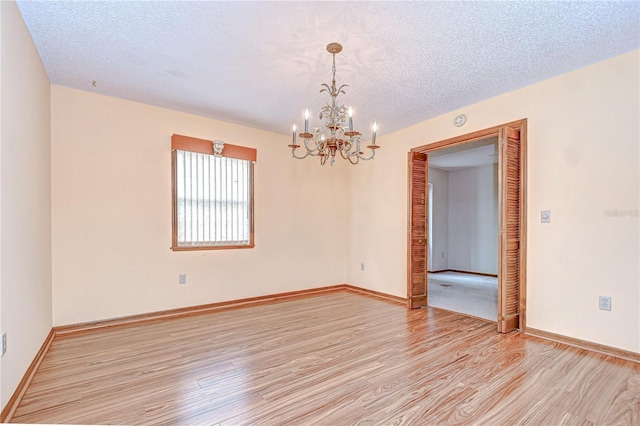 11070 Tilburg St, Spring Hill, FL 34608 - unfurnished room featuring a chandelier, light wood-style flooring, a textured ceiling, and a smoke detector
