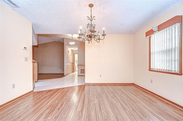 11070 Tilburg St, Spring Hill, FL 34608 - empty room with a textured ceiling, wood finished floors, a chandelier, and vaulted ceiling