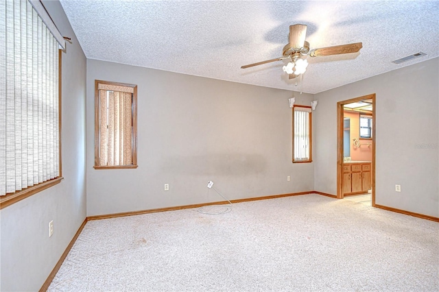 11070 Tilburg St, Spring Hill, FL 34608 - unfurnished bedroom with a textured ceiling, light colored carpet, ceiling fan, and ensuite bath