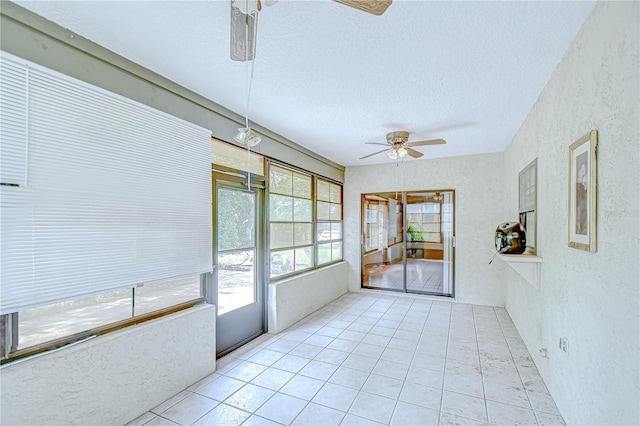 11070 Tilburg St, Spring Hill, FL 34608 - unfurnished sunroom featuring a ceiling fan, healthy amount of natural light, a textured wall, a textured ceiling, and tile patterned flooring