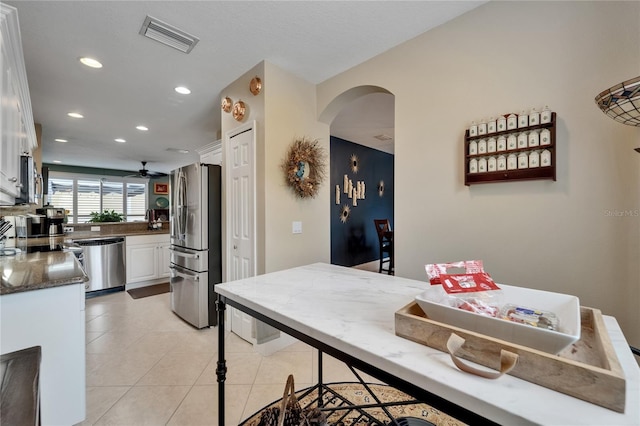 5642 Simonton St, Bradenton, FL 34203 - kitchen with stainless steel appliances, arched walkways, white cabinetry, recessed lighting, and light tile patterned floors