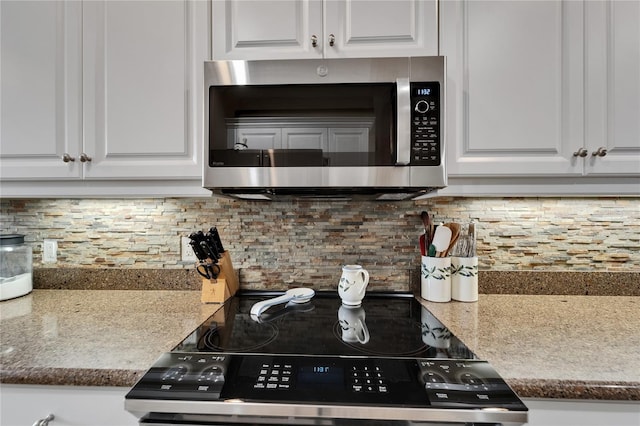 5642 Simonton St, Bradenton, FL 34203 - kitchen with stainless steel microwave, range, white cabinets, and decorative backsplash