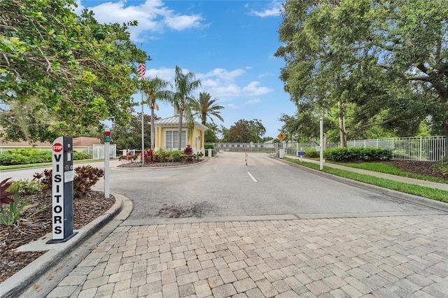 5642 Simonton St, Bradenton, FL 34203 - view of asphalt road with traffic signs, curbs, a gate, and a gated entry