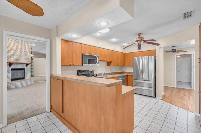 8470 Cranes Roost Dr, New Port Richey, FL 34654 - kitchen with stainless steel appliances, light tile patterned flooring, a textured ceiling, a peninsula, and light countertops