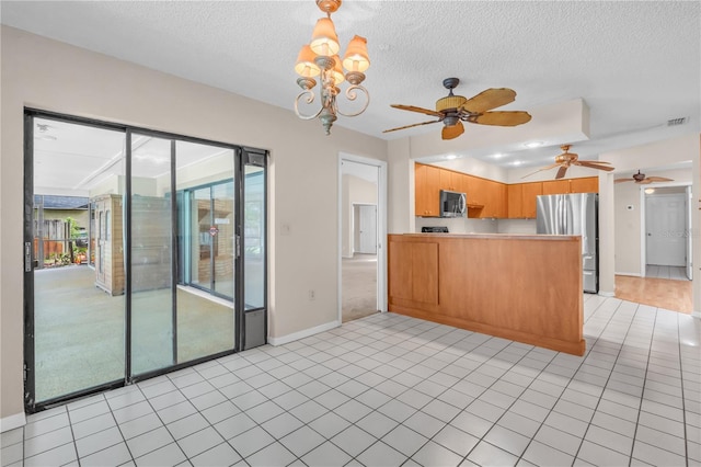 8470 Cranes Roost Dr, New Port Richey, FL 34654 - kitchen with appliances with stainless steel finishes, a peninsula, a ceiling fan, a textured ceiling, and light countertops