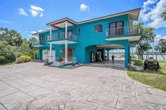 7715 Riverview Dr, Riverview, FL 33578 - view of front facade with a balcony, a carport, concrete driveway, and stucco siding