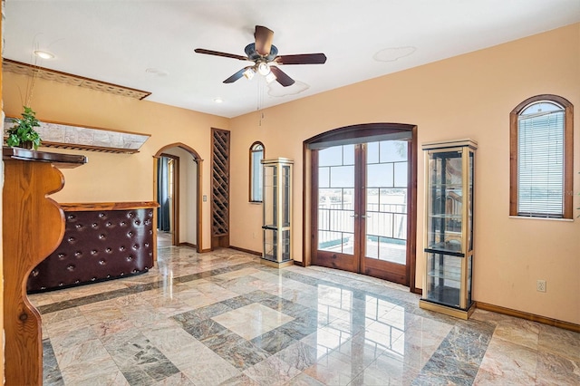 7715 Riverview Dr, Riverview, FL 33578 - empty room featuring arched walkways, french doors, plenty of natural light, and ceiling fan