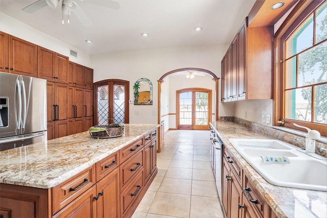 7715 Riverview Dr, Riverview, FL 33578 - kitchen featuring ceiling fan, arched walkways, brown cabinetry, recessed lighting, and a center island