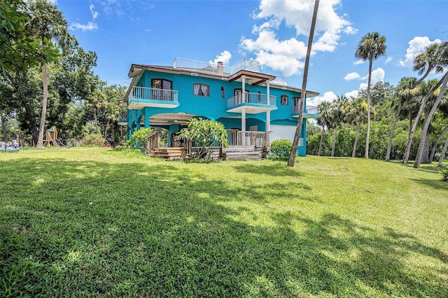 7715 Riverview Dr, Riverview, FL 33578 - rear view of house featuring a balcony and a yard