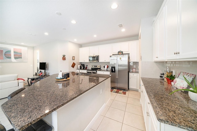 2101 Sunset Wind Loop, Oldsmar, FL 34677 - kitchen featuring appliances with stainless steel finishes, light tile patterned floors, white cabinetry, a kitchen breakfast bar, and recessed lighting