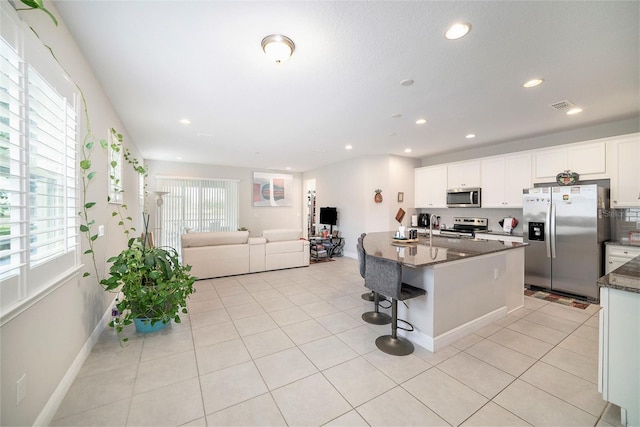 2101 Sunset Wind Loop, Oldsmar, FL 34677 - kitchen featuring stainless steel appliances, plenty of natural light, dark stone countertops, recessed lighting, and white cabinetry