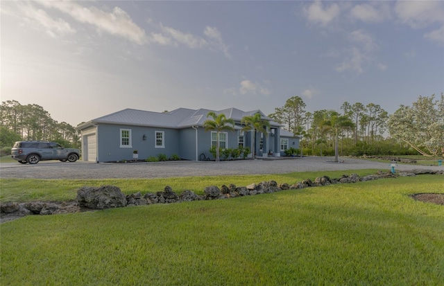 9016 Falcon Ct, Venice, FL 34293 - rear view of house featuring a garage, a yard, a metal roof, and curved driveway