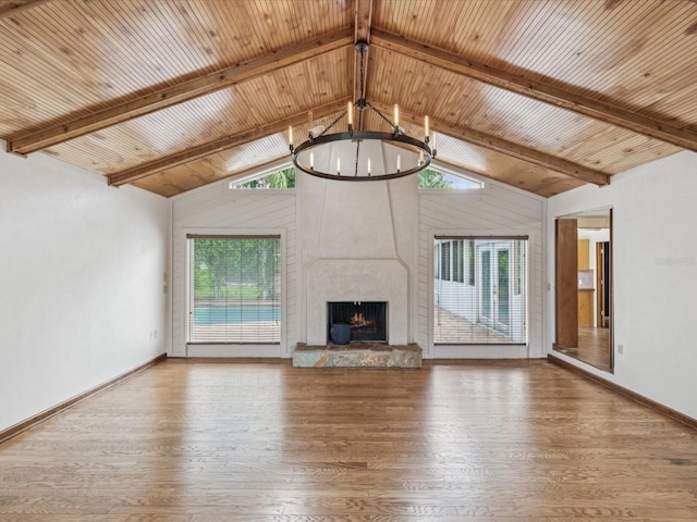 5110 Lake Valencia Blvd E, Palm Harbor, FL 34684 - unfurnished living room featuring a chandelier, healthy amount of natural light, wood finished floors, a large fireplace, and a wooden ceiling with exposed beams