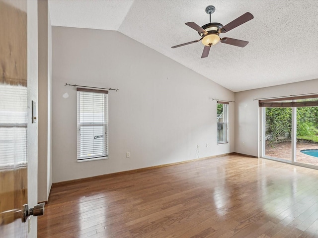 5110 Lake Valencia Blvd E, Palm Harbor, FL 34684 - spare room featuring lofted ceiling, a textured ceiling, wood finished floors, and a ceiling fan