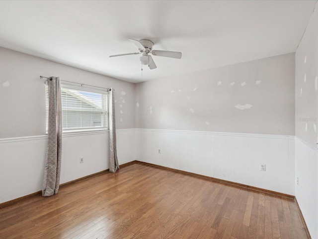 5110 Lake Valencia Blvd E, Palm Harbor, FL 34684 - empty room with wood finished floors, ceiling fan, and wainscoting