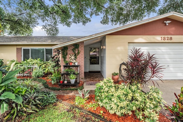 1328 Glenview Ln, Lakeland, FL 33813 - doorway to property featuring an attached garage and brick siding