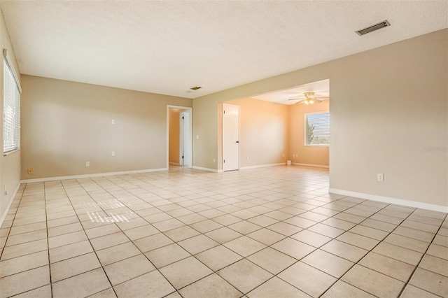 1328 Glenview Ln, Lakeland, FL 33813 - spare room featuring light tile patterned flooring, a ceiling fan, and a textured ceiling