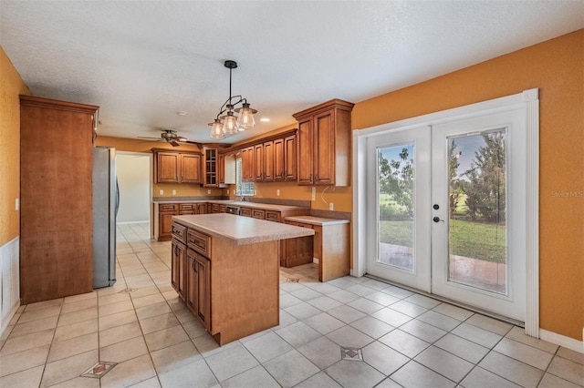 1328 Glenview Ln, Lakeland, FL 33813 - kitchen with brown cabinetry, french doors, light countertops, a center island, and light tile patterned floors
