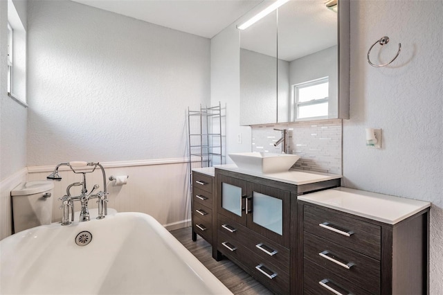 1328 Glenview Ln, Lakeland, FL 33813 - bathroom featuring a freestanding tub, vanity, wood finished floors, wainscoting, and a textured wall
