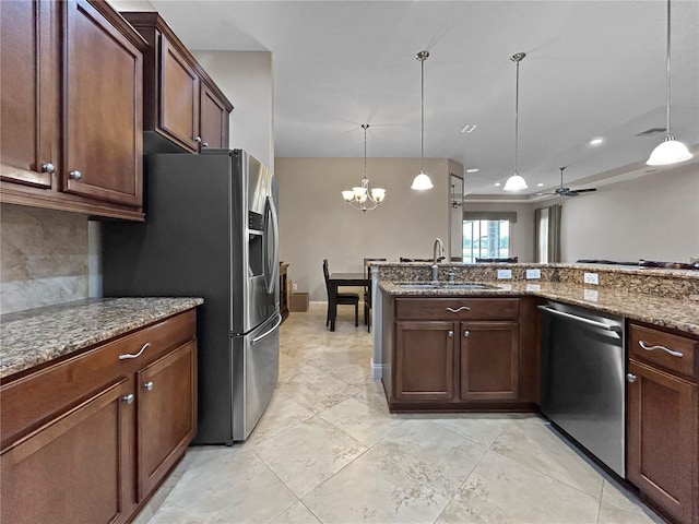 2802 Devonoak Blvd, Land O Lakes, FL 34638 - kitchen with appliances with stainless steel finishes, decorative light fixtures, dark stone countertops, a chandelier, and a ceiling fan