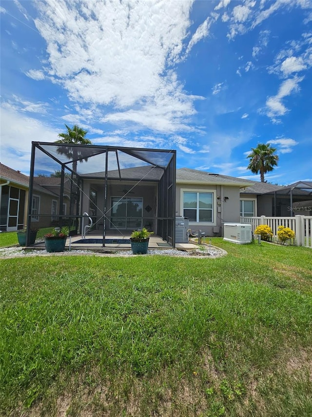 2802 Devonoak Blvd, Land O Lakes, FL 34638 - back of property with a lawn, stucco siding, and glass enclosure