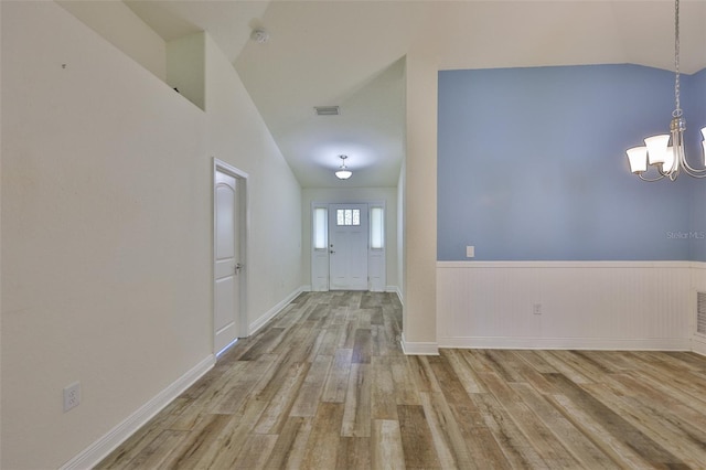 12218 Avondale Oak Pl, Riverview, FL 33578 - entrance foyer with wood finished floors, a chandelier, lofted ceiling, and a wainscoted wall