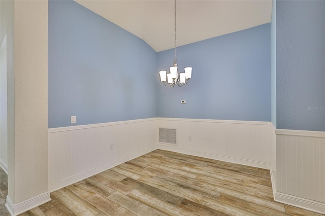12218 Avondale Oak Pl, Riverview, FL 33578 - empty room with wood finished floors, wainscoting, a chandelier, and lofted ceiling
