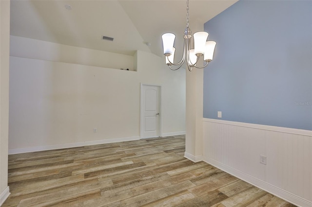 12218 Avondale Oak Pl, Riverview, FL 33578 - spare room featuring a chandelier, wood finished floors, wainscoting, and vaulted ceiling