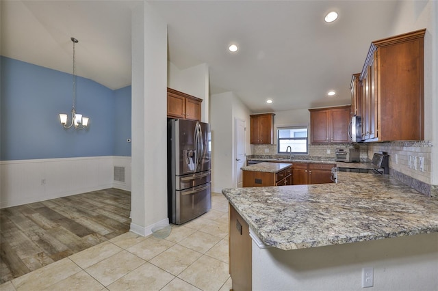 12218 Avondale Oak Pl, Riverview, FL 33578 - kitchen with stainless steel appliances, a chandelier, backsplash, wainscoting, and a peninsula