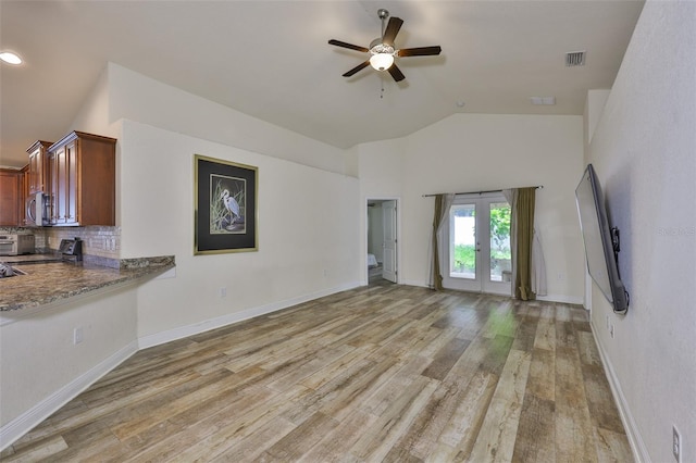 12218 Avondale Oak Pl, Riverview, FL 33578 - unfurnished living room featuring a ceiling fan, light wood-type flooring, french doors, and high vaulted ceiling