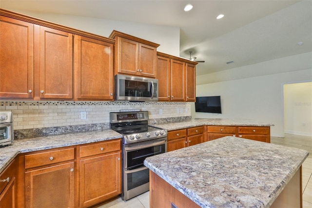 12218 Avondale Oak Pl, Riverview, FL 33578 - kitchen with stainless steel appliances, decorative backsplash, brown cabinets, a peninsula, and recessed lighting