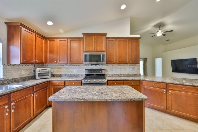 12218 Avondale Oak Pl, Riverview, FL 33578 - kitchen with stainless steel appliances, vaulted ceiling, light tile patterned floors, ceiling fan, and decorative backsplash